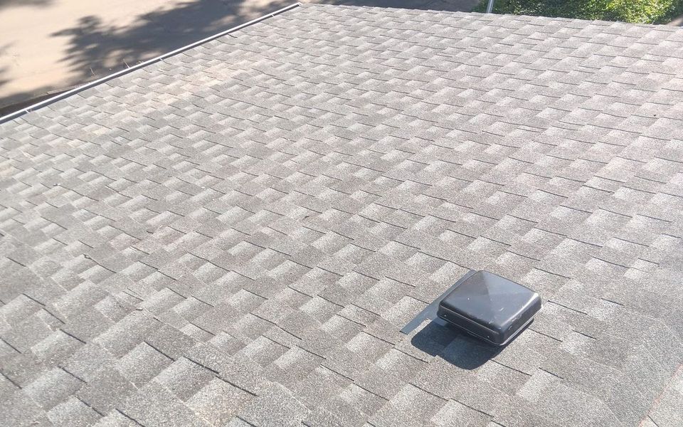 A new grey architectural shingle roof installed by Silver Ridge Roofing, seen from the ridge